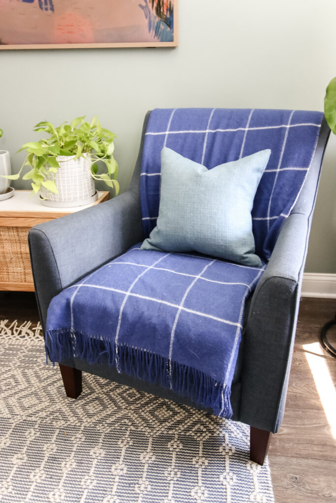 blanket folded on a chair with throw pillow