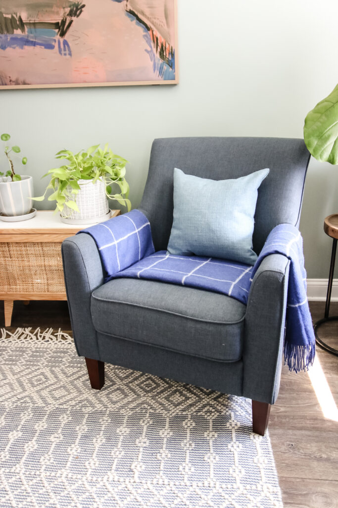 blanket folded on a chair with throw pillow