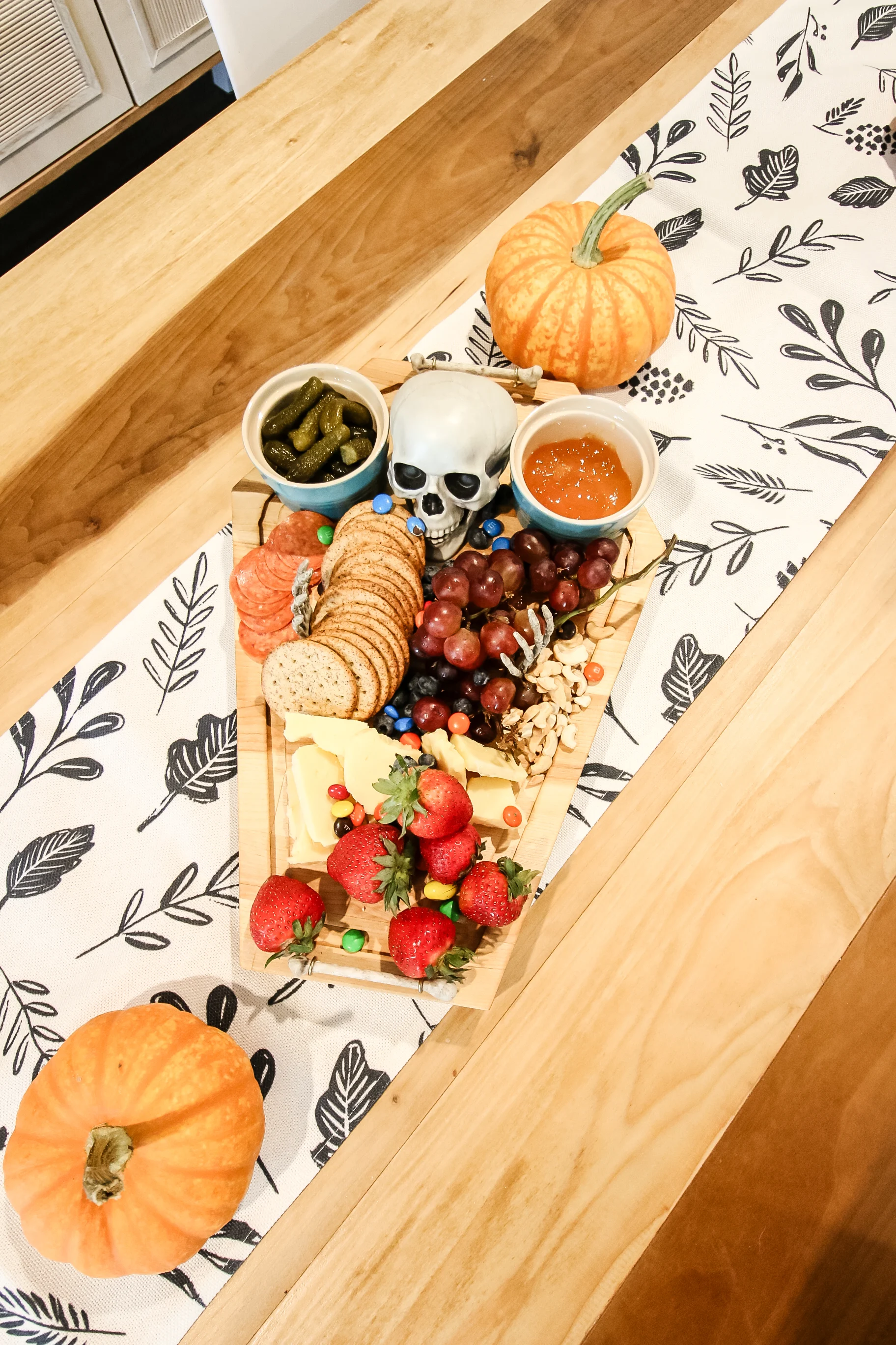 DIY skeleton cheeseboard with food on table