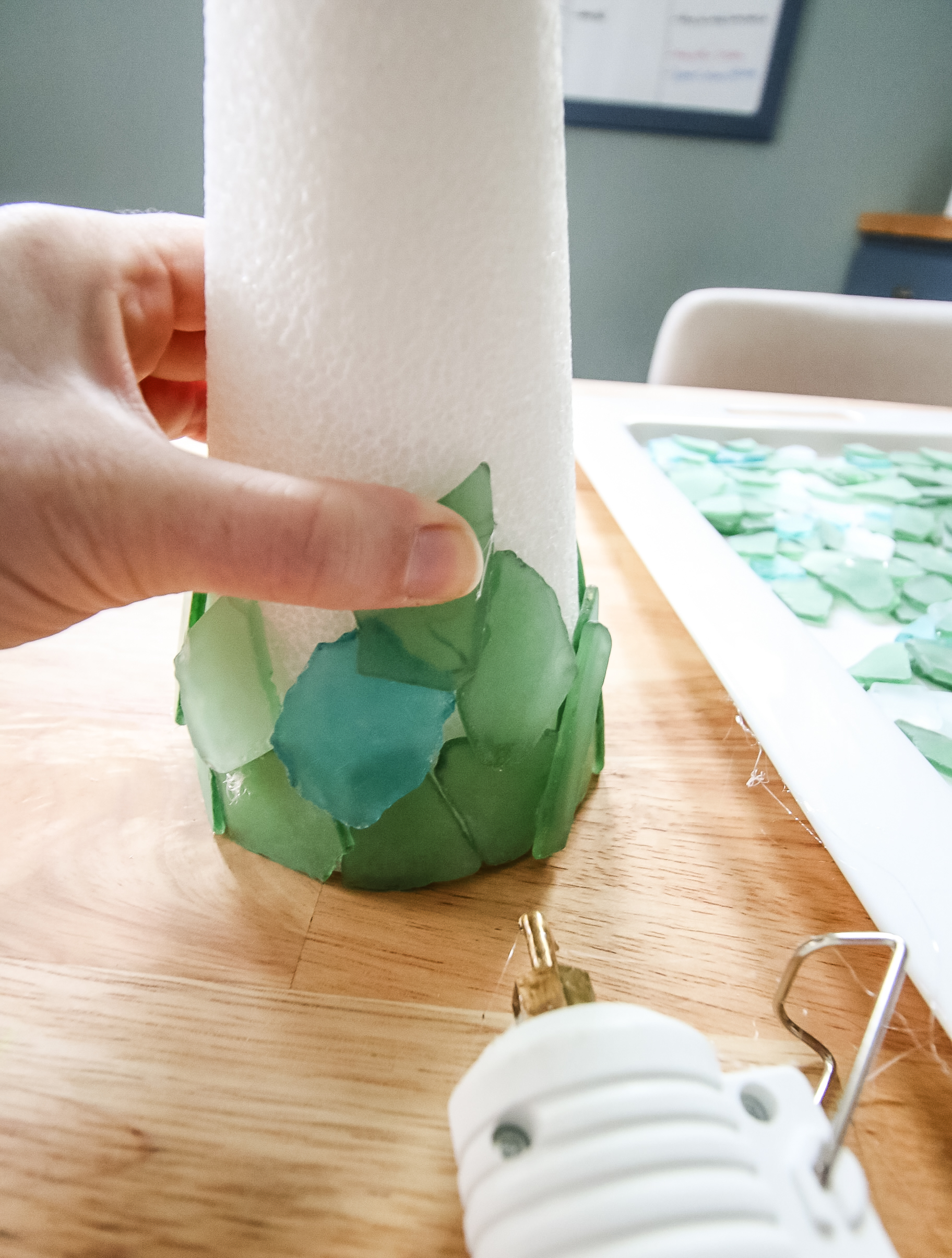 hot gluing sea glass to a christmas tree