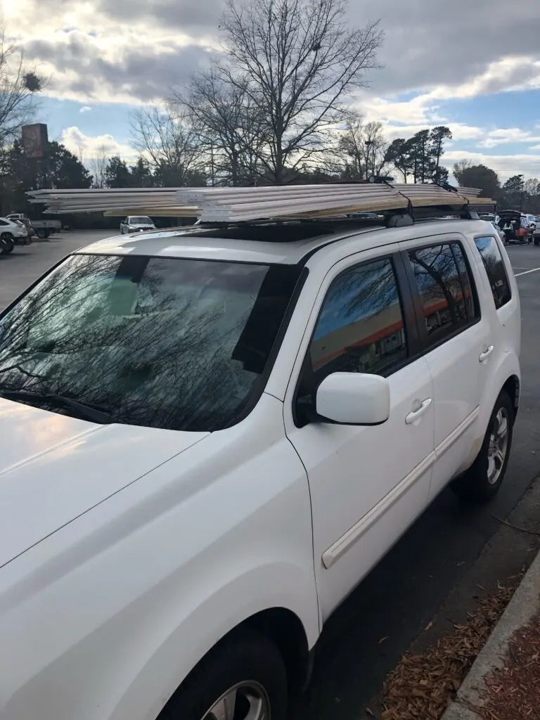 Lumber strapped to roof of car