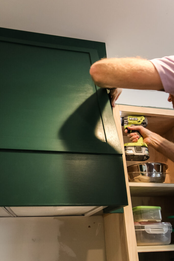 Screwing range hood cover into place