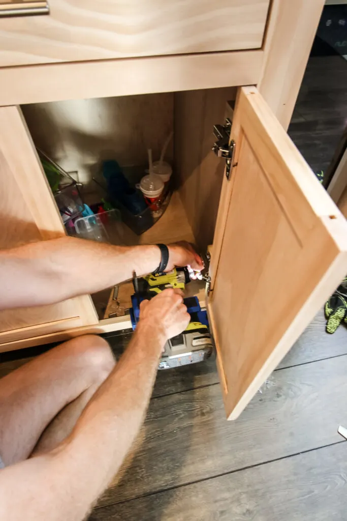 screwing hinges into a cabinet