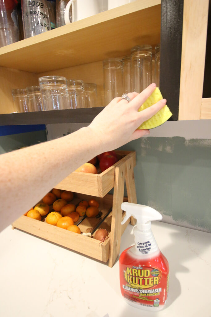 cleaning kitchen cabinets with a sponge