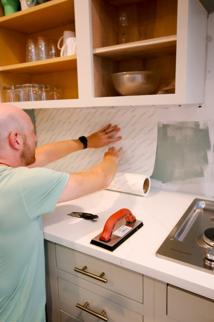 applying musselbound peel and stick adhesive sheets to the wall