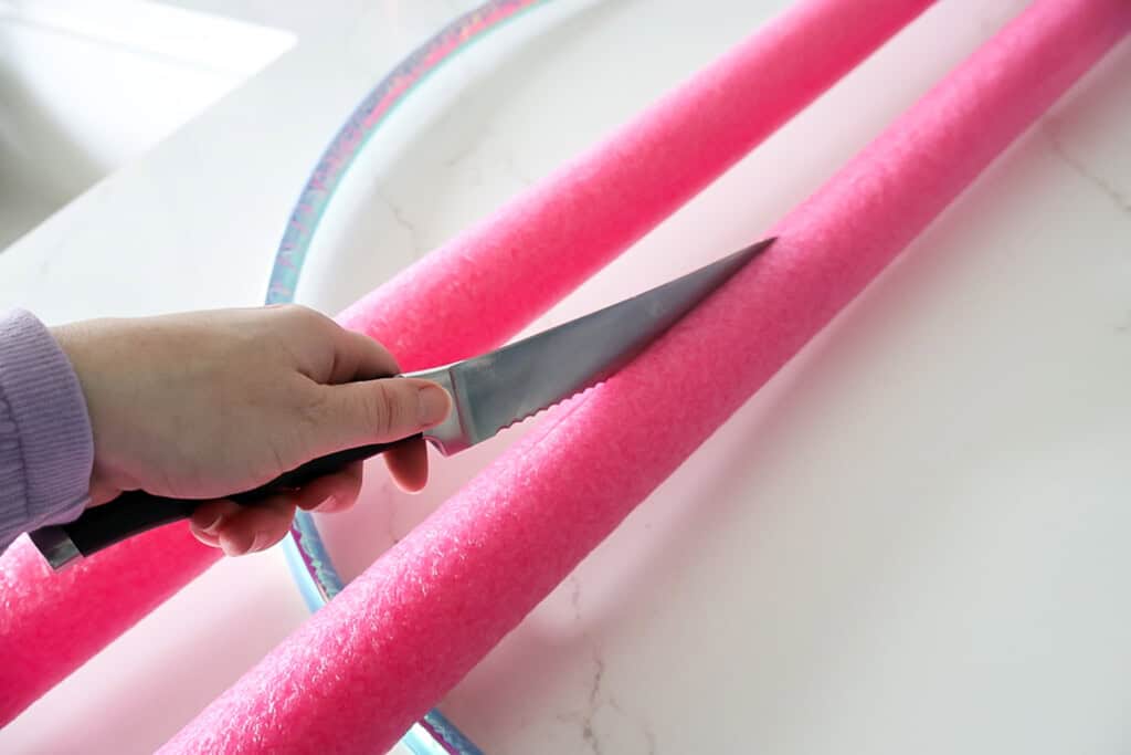 putting pool noodles on a hula hoop 