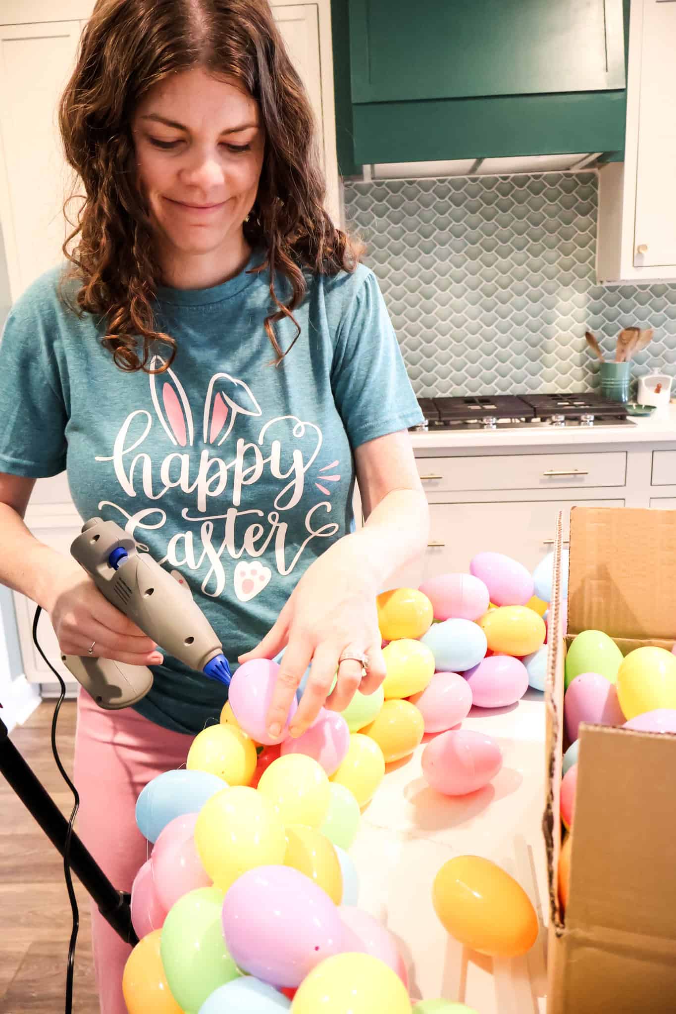 hot gluing easter eggs onto a wreath