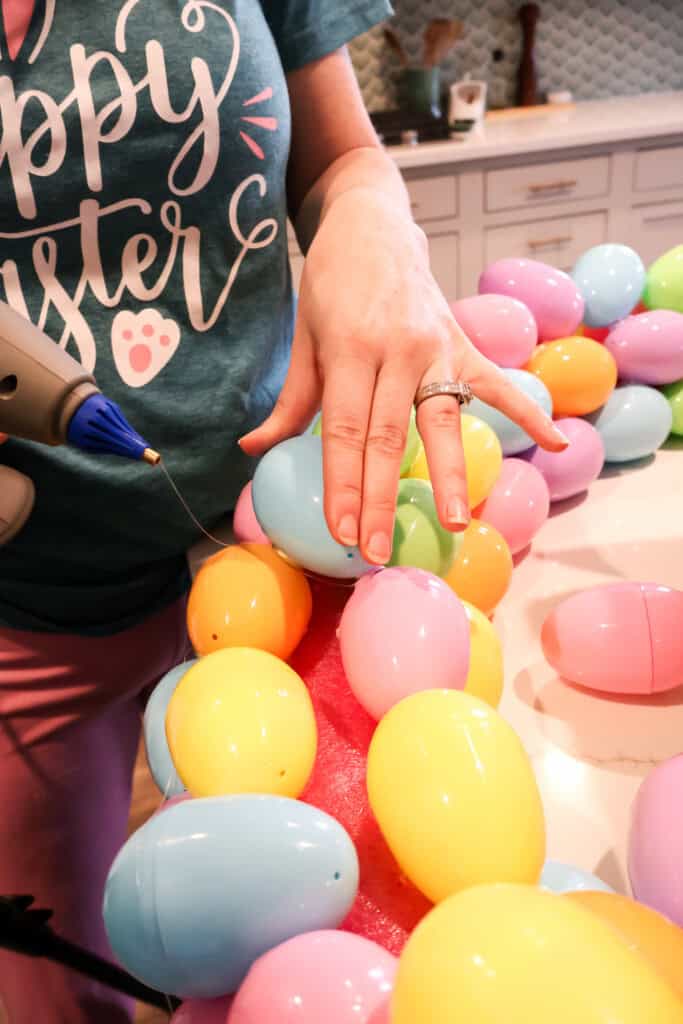 hot gluing easter eggs onto a wreath