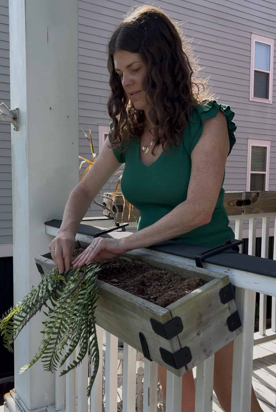 adding plants to a faux plant tropical windowbox planter