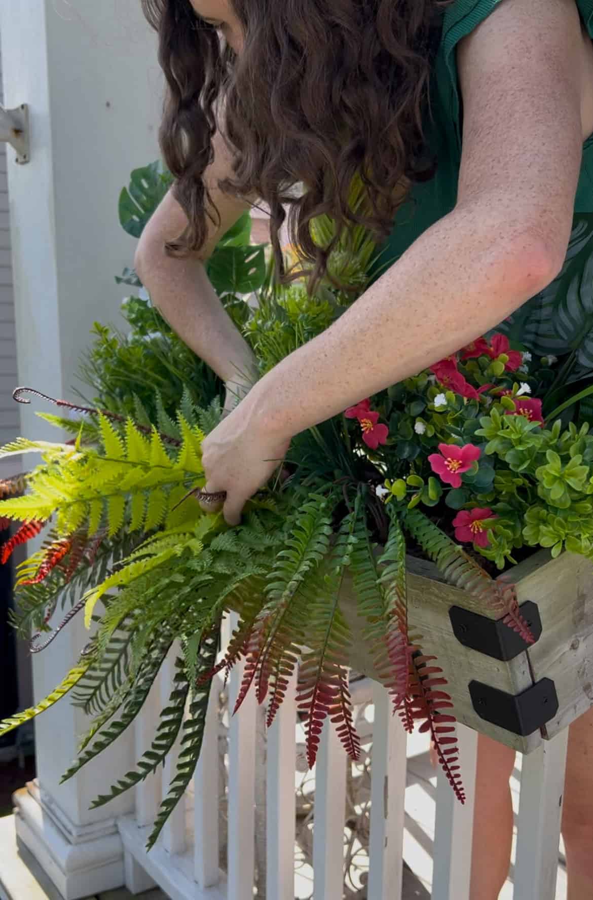 adding plants to a faux plant tropical windowbox planter