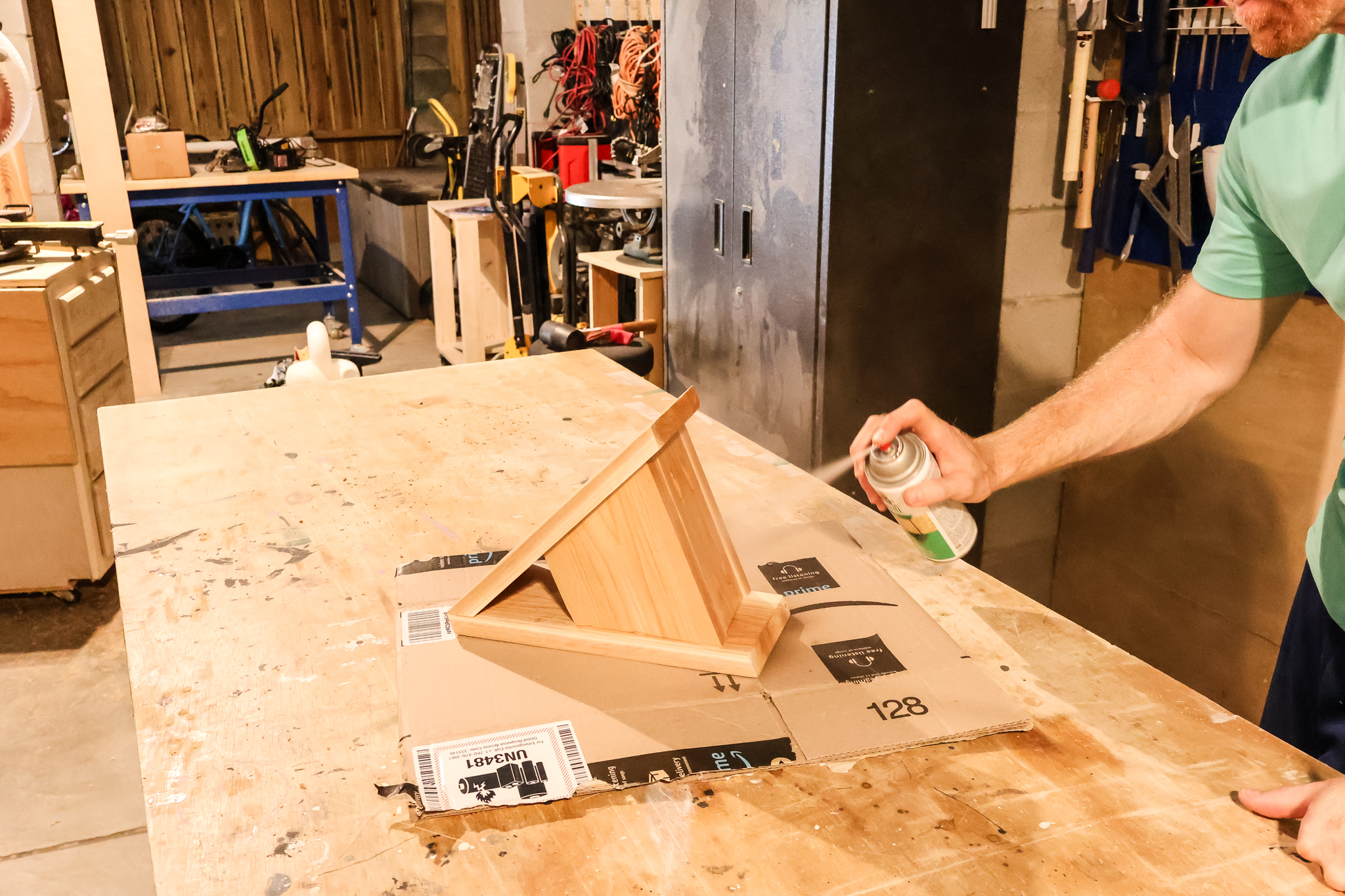 Adding spray sealant to birdhouse