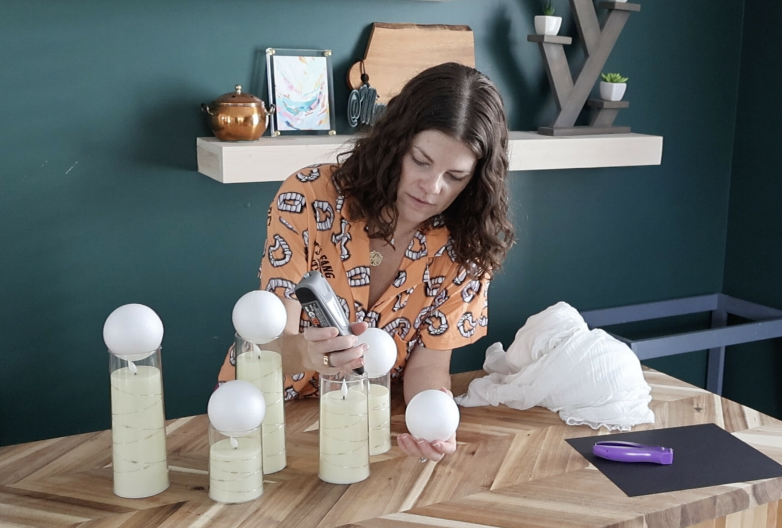 hot gluing styrofoam balls to candles